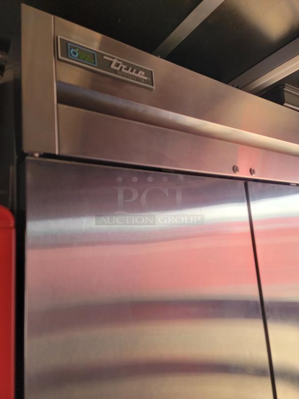 True commercial refrigerator with stainless steel finish, visible logo, pristine condition, energy-efficient label.