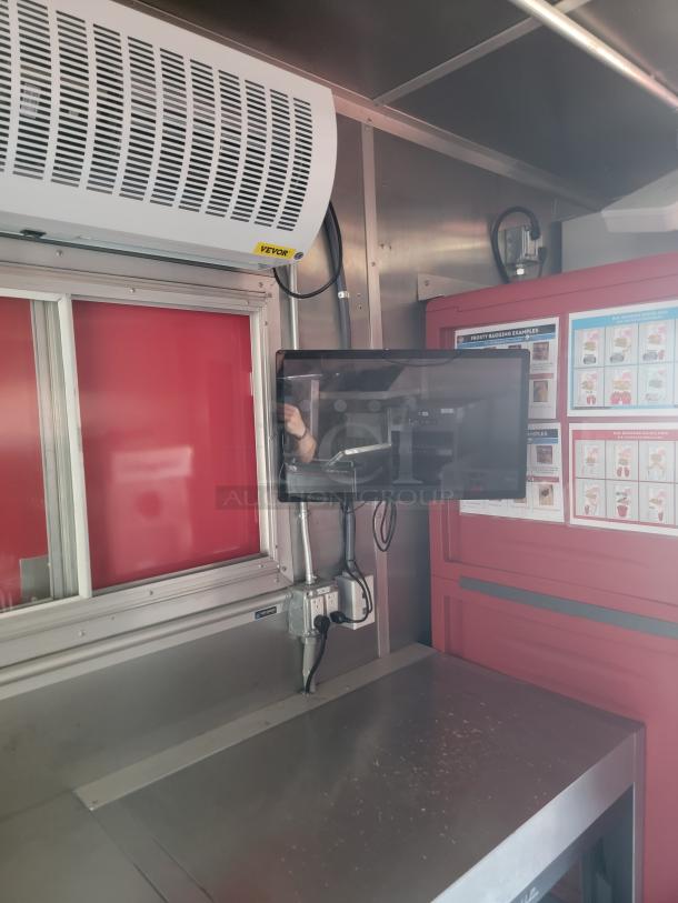 Industrial stainless steel workspace with Vevor air curtain, power outlet, and overhead monitor setup.