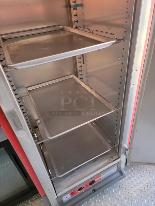Commercial stainless steel warming cabinet with adjustable trays, red accents, and control panel; appears in good condition.