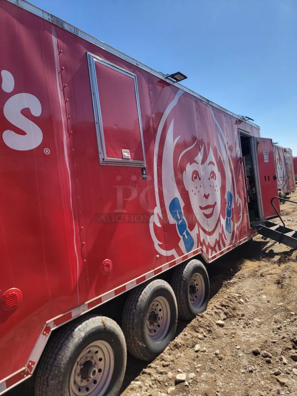 Red mobile food trailer with Wendy's logo, triple axle, sliding window, minor wear.