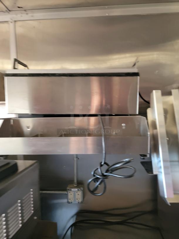 Stainless steel commercial kitchen equipment with attached power cords and visible outlets, in used condition.