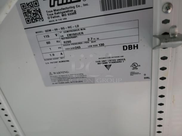 Label on True Manufacturing refrigerator model QDM-09-SQ-HC-LD. Details: 115V, refrigerant R290, suitable for outdoor use.
