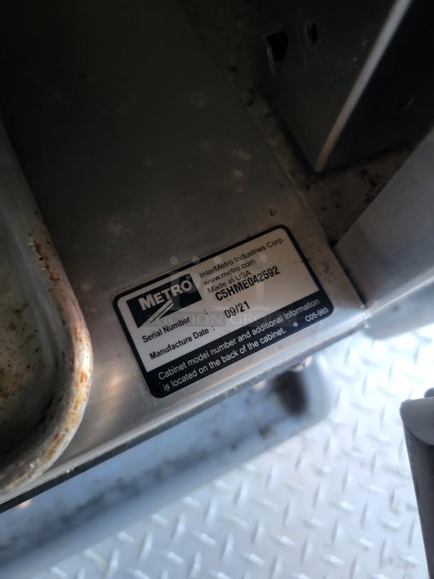 Metal cabinet with visible Metro label, serial C5HNEA012592, manufactured 09/21. Notably rusted rim, made in USA.