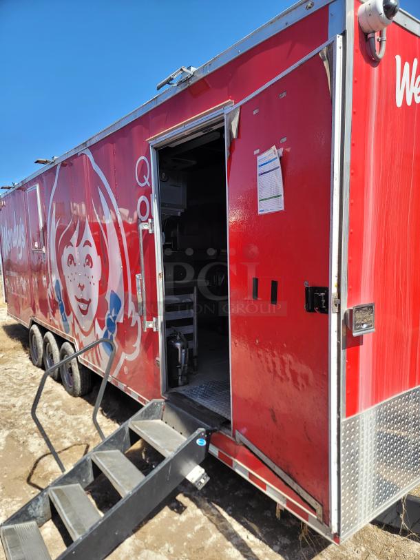 Red Wendy's food trailer with side entrance, showing kitchen interior. Visible logo and signage on exterior. Stairs attached.