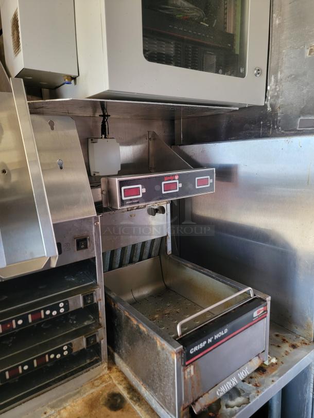 Commercial kitchen equipment with heating and holding units. Features "Crisp N' Hold" brand, shows signs of wear and rust.