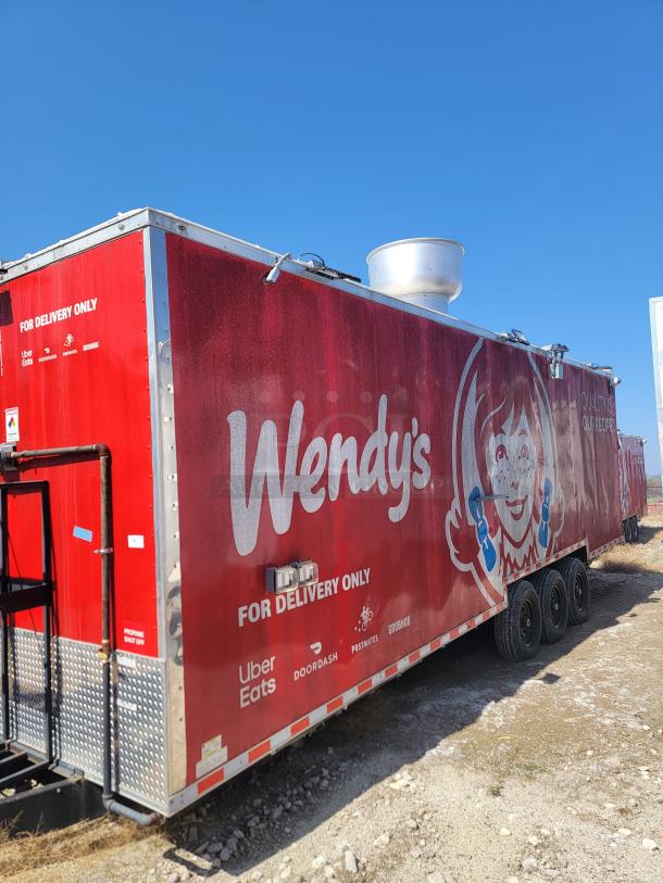Red Wendy's mobile kitchen trailer with "For Delivery Only" signage. Features logos of Uber Eats, DoorDash, Postmates, Grubhub.