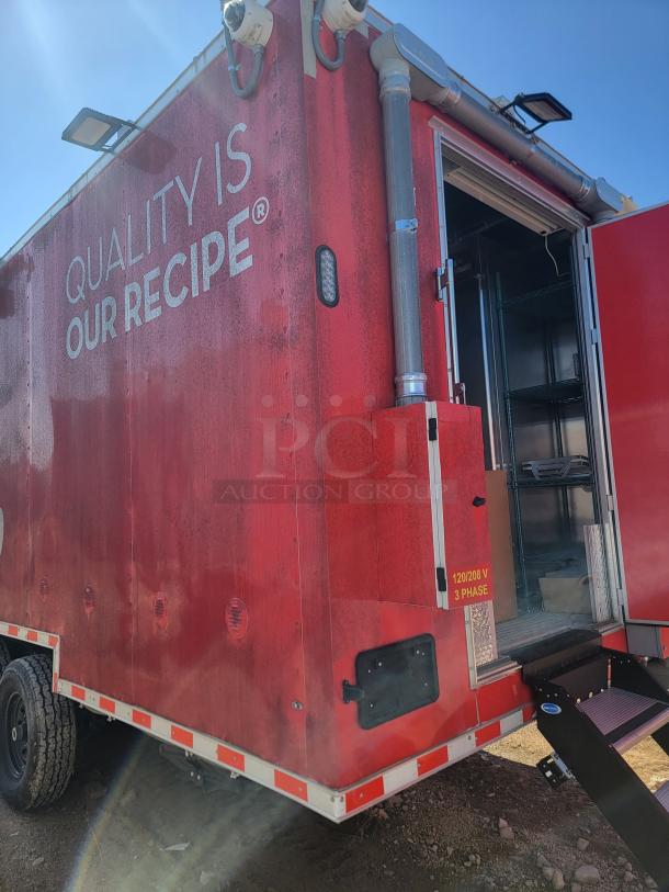 Red food truck with "Quality is Our Recipe" text, equipped with security cameras and a 120/208V 3-phase electrical panel.