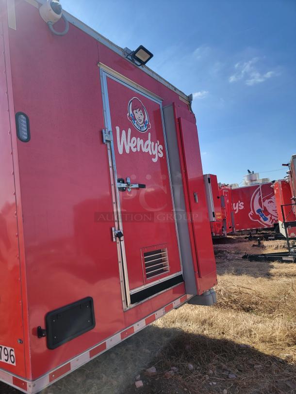 Red Wendy's food truck, side view, showing logo and access door. Clean condition with visible security camera and ventilation panel.