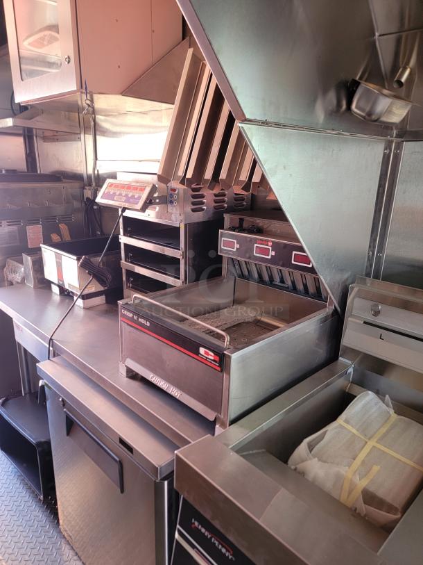 Commercial kitchen equipment setup with stainless steel construction, including a Crisp N’ Hold warmer. Clean and well-maintained.