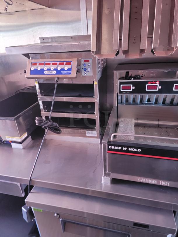 Commercial kitchen equipment set with Perfect Fry heat lamp featuring control panel, and Crisp N' Hold warming unit. Good condition.