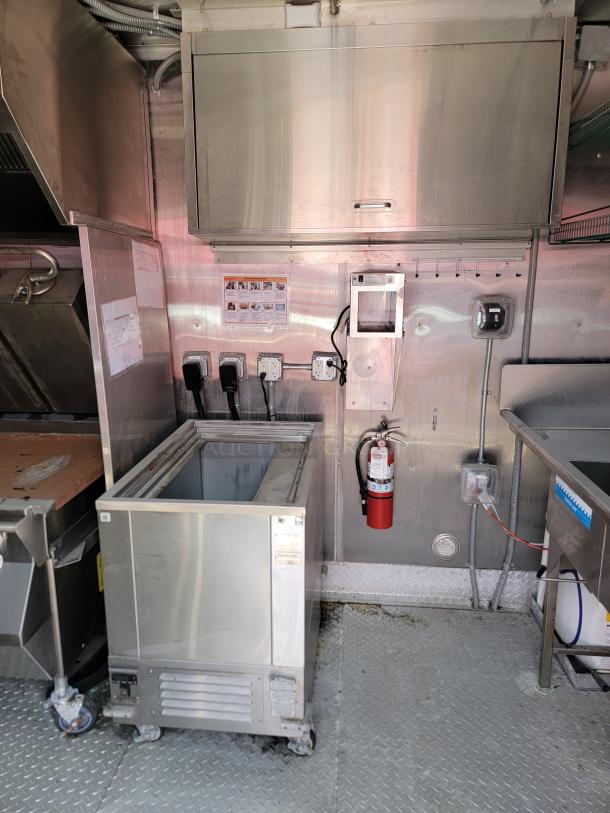 Commercial stainless steel freezer on casters, used condition. Features side venting and label indicating model information.