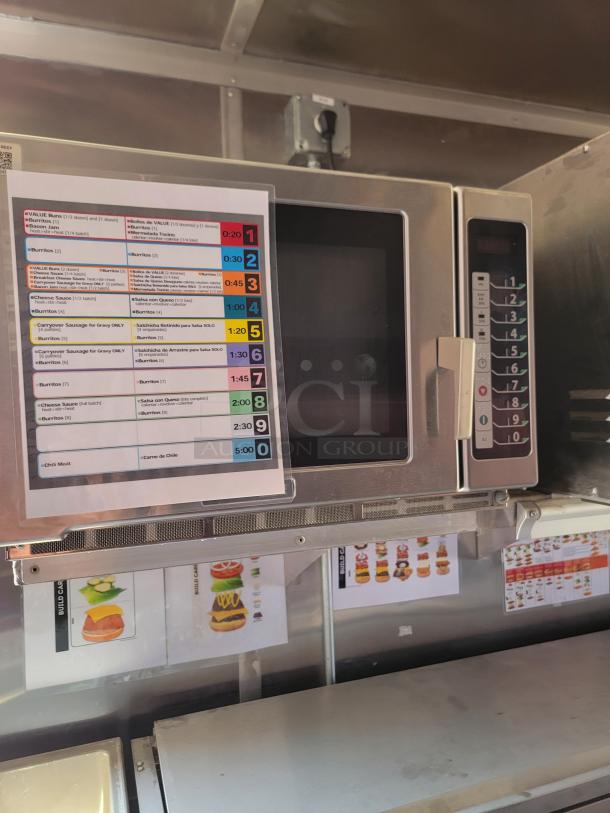 Commercial microwave oven with digital keypad and cooking guide chart. Clean condition. No visible brand or model.
