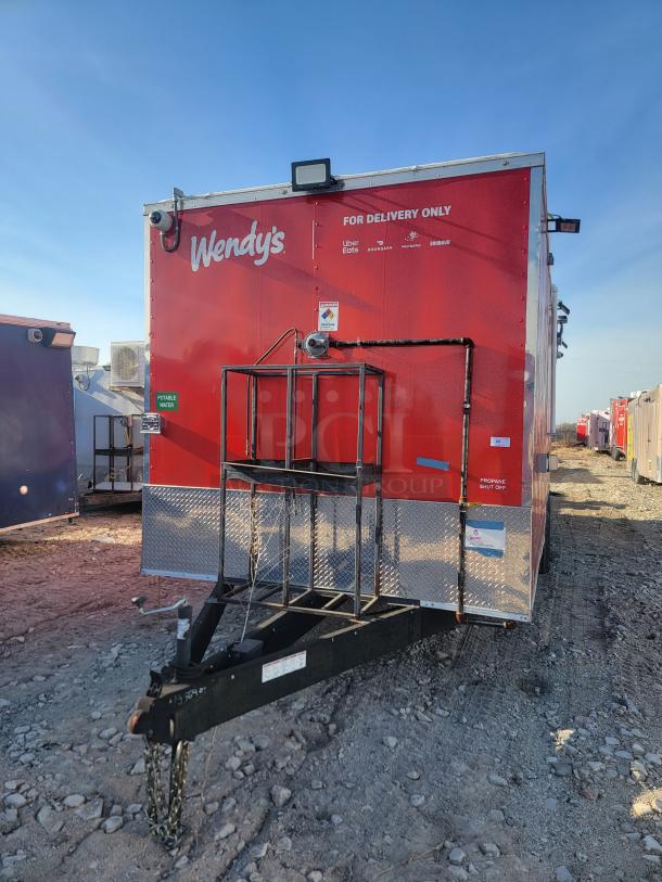 Red Wendy's food trailer, marked "For Delivery Only" with service logos. Visible portable water and propane shutoff labels.