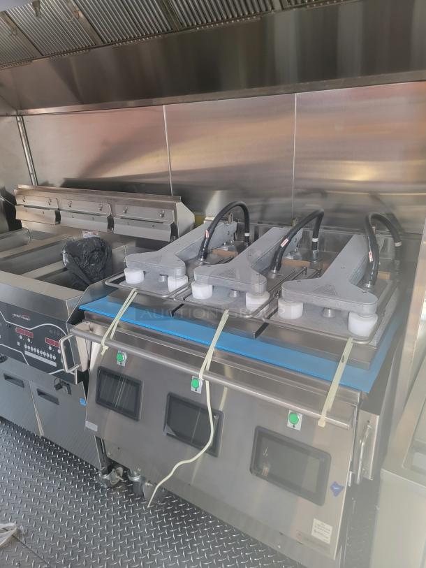 Commercial kitchen equipment featuring three industrial panini presses and stainless steel appliances, well-maintained.