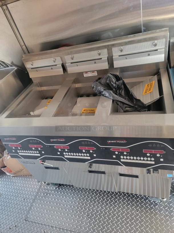 Henny Penny commercial fryer, stainless steel, with digital controls, three compartments, labeled "L" and "R," new condition.