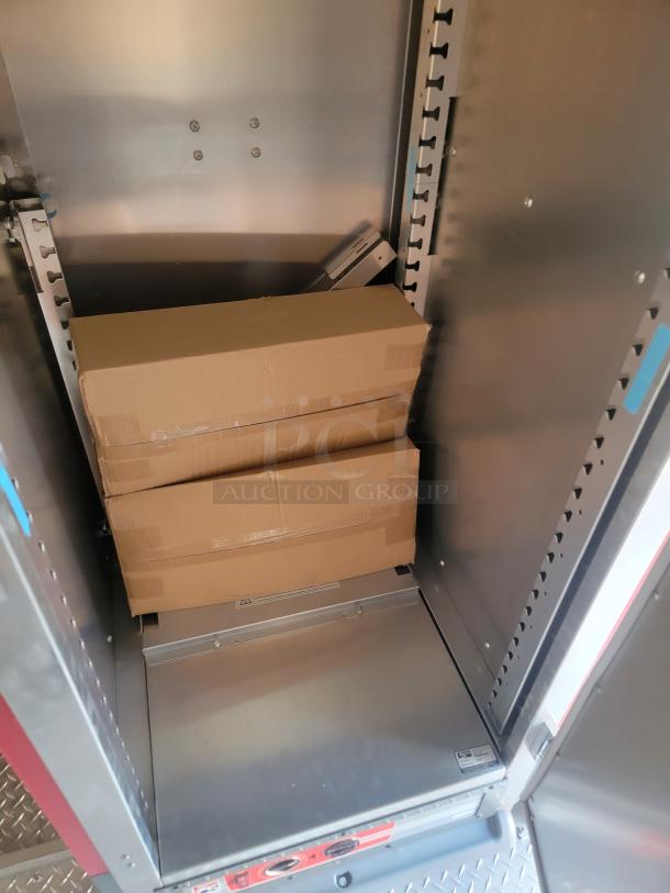 Cardboard boxes stacked inside a metal storage compartment, secured and unmarked. Condition appears new. No visible labels.