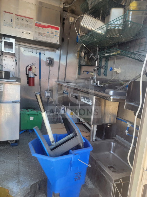 2021 Rock Solid Cargo 8.5'x28' mobile kitchen trailer interior, featuring sinks, storage, and a CaptiveAire hood.