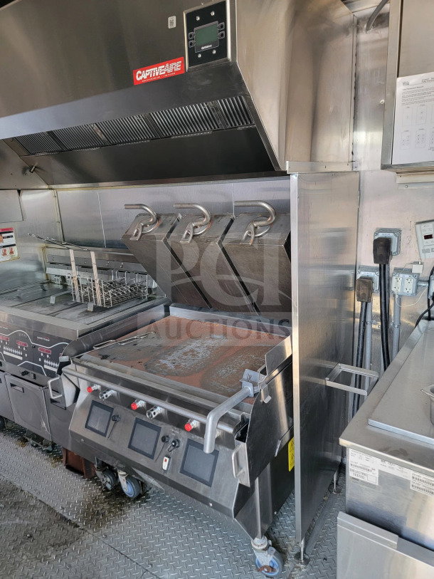 "2021 Rock Solid Cargo 8.5' x 28' mobile kitchen trailer interior, featuring CaptiveAire hood, full kitchen suite, triple-axle; Model 28."