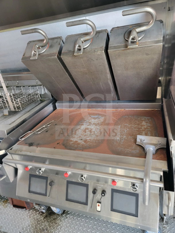 Triple fryer system in 2021 Rock Solid Cargo mobile kitchen trailer, CaptiveAire hood visible, stainless steel, used condition.