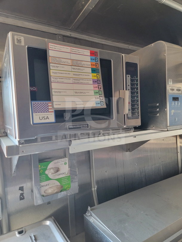 2021 Rock Solid Cargo 8.5' x 28' mobile kitchen trailer interior, featuring a Menumaster microwave with cooking chart and USA label.