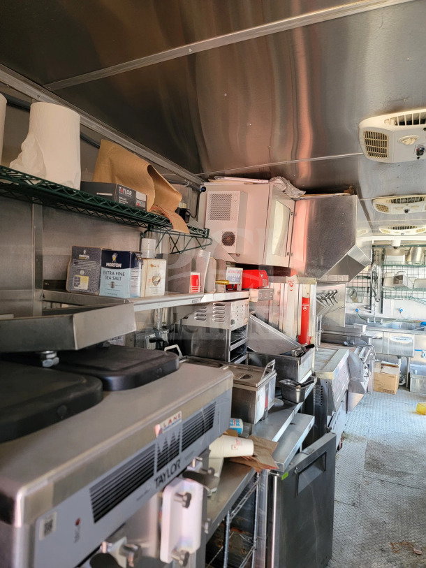 2021 Rock Solid Cargo 8.5' x 28' mobile kitchen trailer interior with full kitchen suite, CaptiveAire hood, and triple-axle setup.