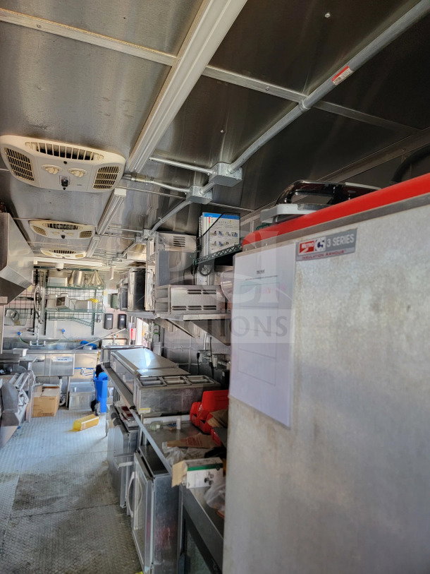 2021 Rock Solid Cargo 8.5' x 28' mobile kitchen trailer interior. Features CaptiveAire hood, stainless steel appliances, and full kitchen suite.