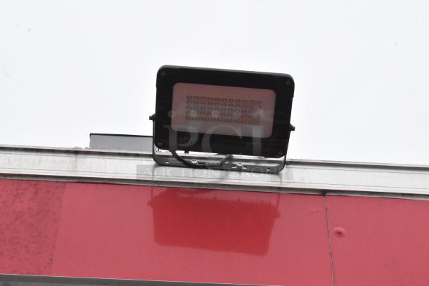 Close-up of 50W IP66 exterior light on red surface of Wendy's Mobile Kitchen Trailer.
