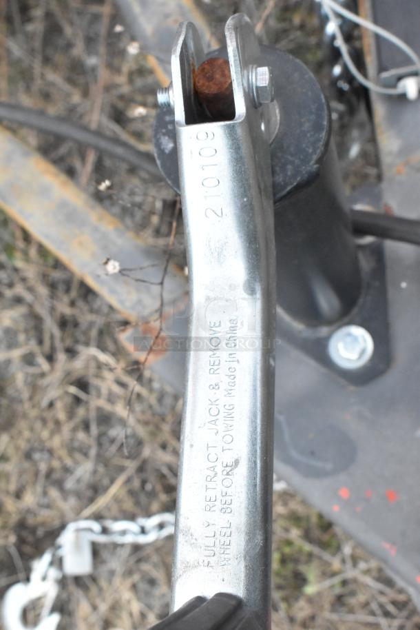 Trailer hitch with metal components and text engraved: "Fully Retract Jack & Remove Wheel Before Towing Made in China" and number "210109".