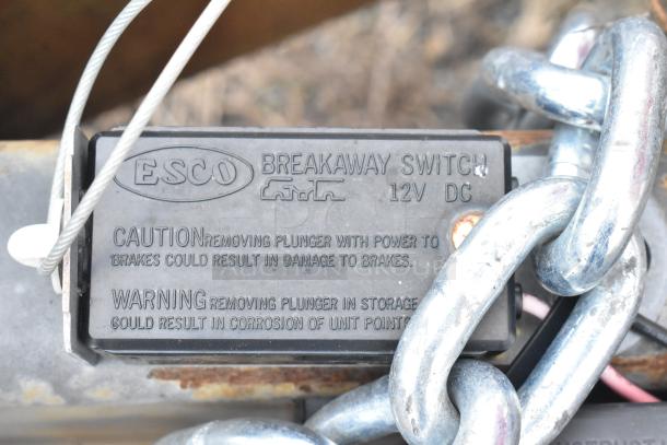 ESCO Breakaway Switch with caution and warning labels, attached to a metal chain.