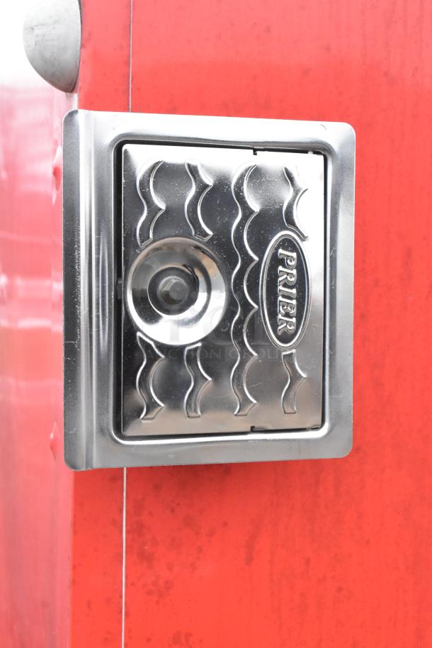 Close-up of a stainless steel Prier hose bib on a red mobile kitchen trailer.