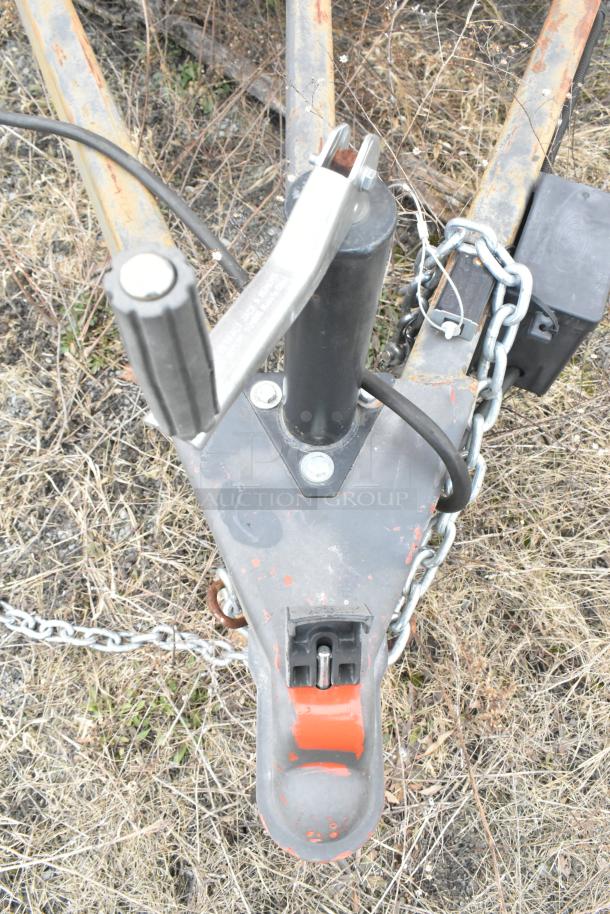 Trailer hitch of Wendy's Mobile Kitchen Trailer, showing locking mechanism, safety chains, and electrical connections.
