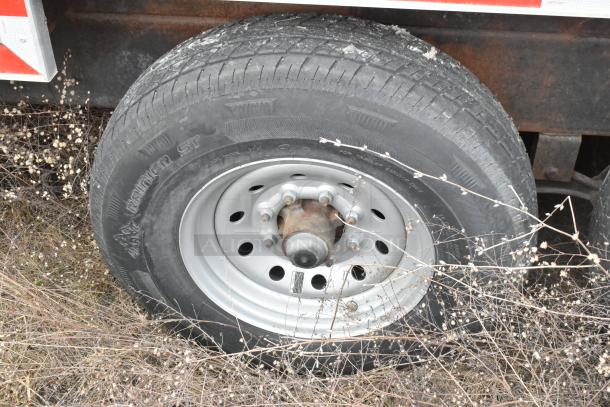 Close-up view of a trailer wheel with a steel rim and tire on an 8.5' x 28' Wendy’s mobile kitchen trailer.