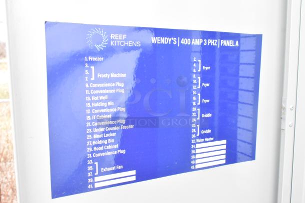 Blue electrical panel label for Wendy's mobile kitchen trailer, listing equipment and outlets such as freezer, fryer, and griddle.