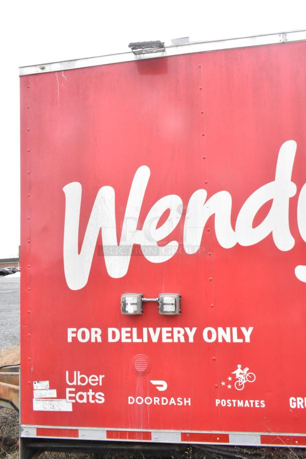 Red Wendy's mobile kitchen trailer, branded for delivery only with logos of Uber Eats, DoorDash, Postmates.