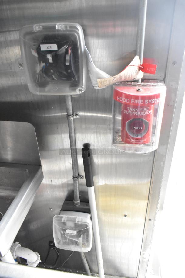 Wendy's mobile kitchen trailer interior, showing a hood fire suppression system and electrical elements.