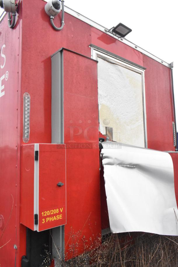 Red Wendy's mobile kitchen trailer with visible 120/208V 3-phase electrical panel; some exterior wear.