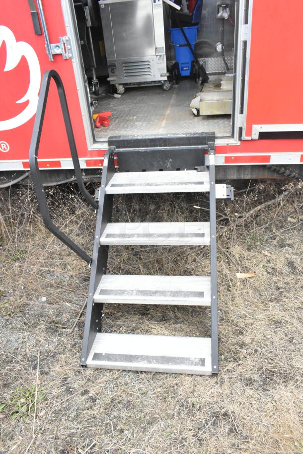 Exterior view of a Wendy's mobile kitchen trailer with retractable steps. Trailer features stainless steel equipment inside.