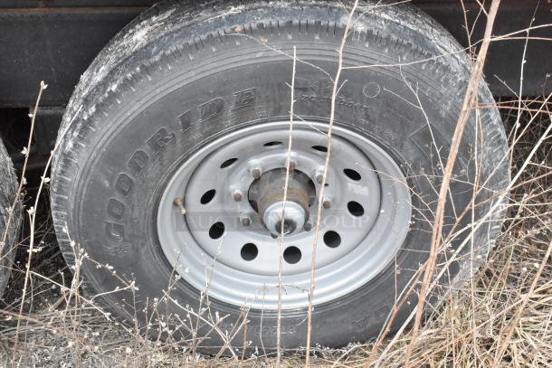 Close-up of a Goodyear tire on a mobile kitchen trailer, showing treads and wheel hub in an outdoor setting.