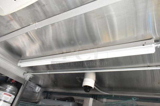 Interior view of new Wendy's mobile kitchen trailer, showing stainless steel ceiling, lighting, and part of equipment setup.