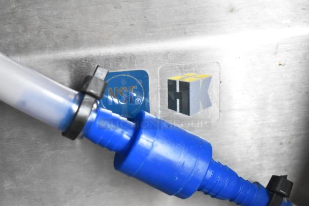 Close-up of a Wendy's Mobile Kitchen Trailer feature with NSF and HK labels, showcasing plumbing components.