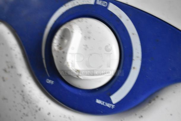 Close-up of a blue and white control dial on equipment, showing "Off," "Mid," and "Max/Hi" settings, with visible wear.