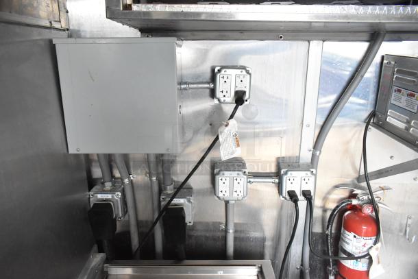Electrical panel in brand new 8.5' x 28' Wendy's mobile kitchen trailer. Multiple outlets, wiring, and fire extinguisher visible.