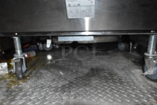 8.5' x 28' Wendy's Mobile Kitchen Trailer underside view, featuring triple axle and casters.