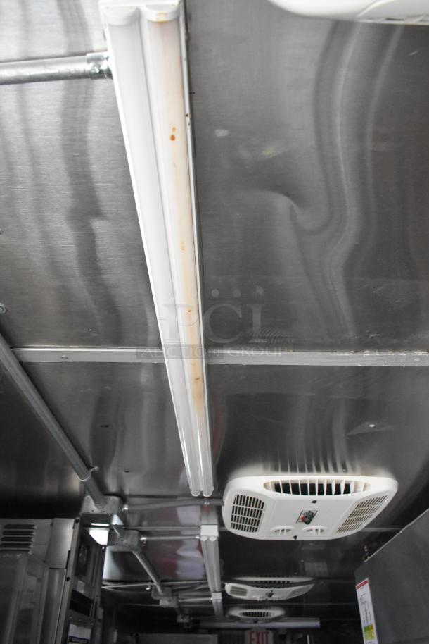 Interior ceiling of a brand new Wendy's mobile kitchen trailer showing lighting and air conditioning unit.