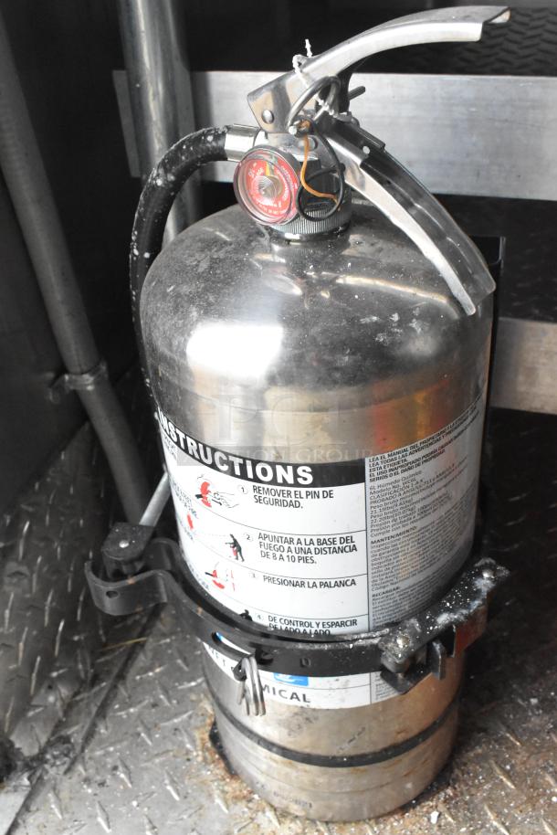 Fire extinguisher inside a Wendy's mobile kitchen trailer with instructions label visible.