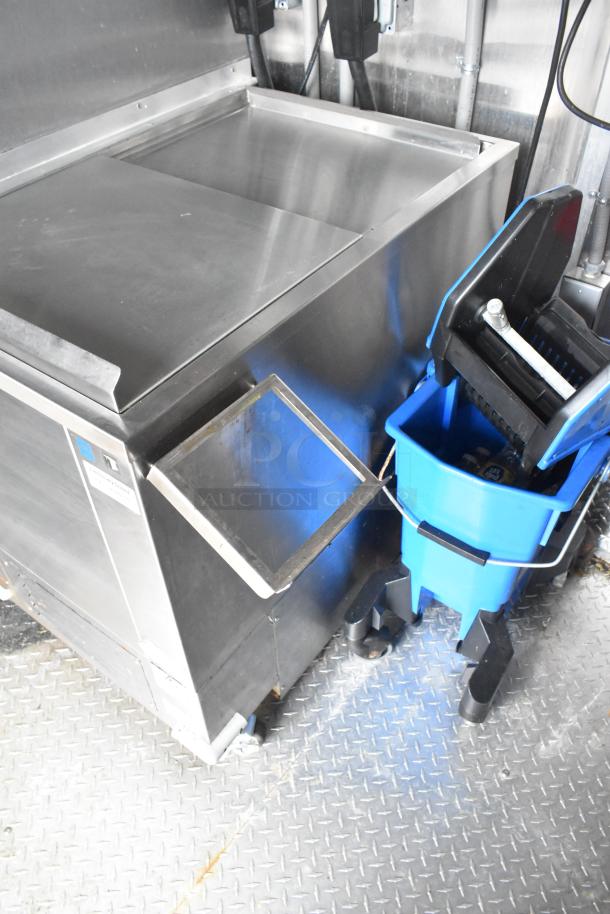 Stainless steel equipment inside a brand new 8.5' x 28' Wendy's mobile kitchen trailer.
