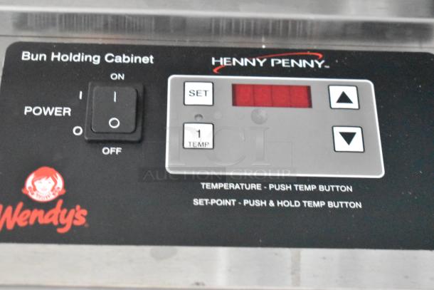 Henny Penny bun holding cabinet controls with Wendy's logo, showing power switch and temperature settings.