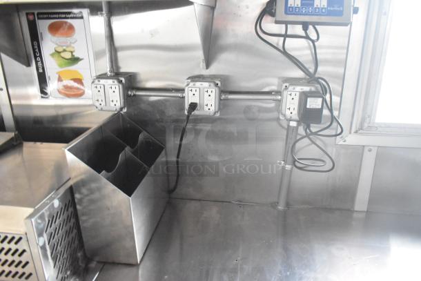 Interior of new Wendy's mobile kitchen trailer showing stainless steel surfaces, electrical outlets, and condiment holder.