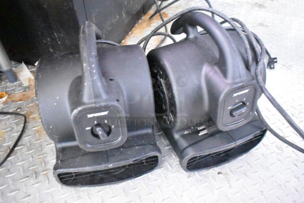 XPOWER floor dryers on a textured metal surface, featuring variable speed controls and sturdy handles.