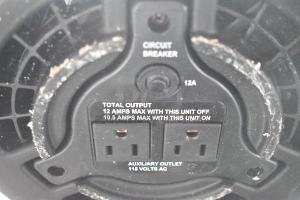 Electrical outlet on mobile kitchen trailer with circuit breaker, showing 12 amps max off, 10.5 amps max on, 115 volts AC.